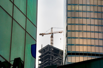 A fragment of a construction site on the background of two modern buildings. Close-up. A beautiful combination of various building structures and geometric details. The image of a modern city.