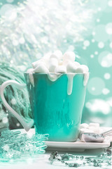 Cup of cocoa with cream with marshmallows, Christmas decor on background with bokeh in trendy color 2020 Aqua Menthe. 