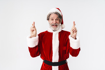 Fototapeta na wymiar Image of Santa Claus man in red costume keeping fingers crossed