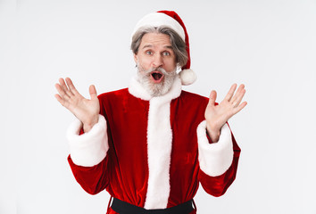 Fototapeta na wymiar Image of gray-haired Santa Claus old man in red costume expressing wonder