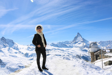 Asian woman traveler posing with mountain Matternhorn in winter season and clear sky