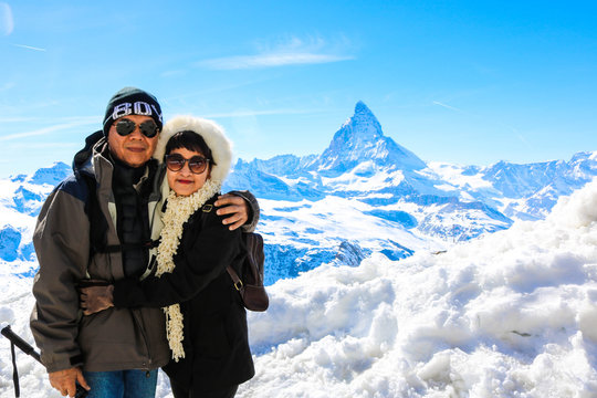Asian Senior Couple Posing With Mountain Matternhorn In Winter Season And Clear Sky