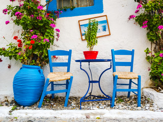 Fototapeta na wymiar Greece: Typical Greek Blue Chairs and Table in a small Cafeteria