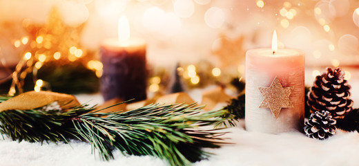 Romantic winter and christmas greeting card with text - Burning candle with natural fir and pine cone decoration on a bright background and copy space