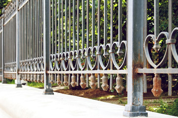 Forged metal fence with hearts. Gate with chain