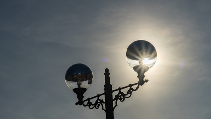 Sunshine behind Street light on the sky background. Sochi, Russia.