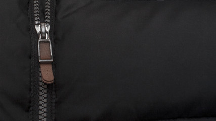 Close-up open zipper on a black down jacket.