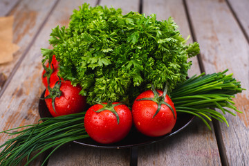 Fresh bright vegetables and herbs on a wooden table.