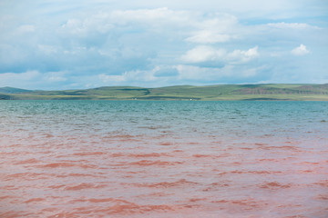 Ripples on a salt lake with pink and azure blue water