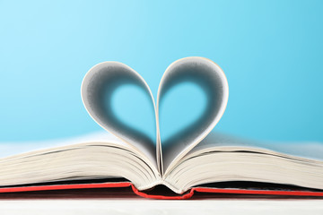 Heart made of pages. Book against blue background, space for text