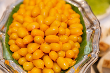 Image of Thai desserts. The name of the dessert is Met Khanoon. It is a Thai dessert with a sweet taste of sugar mixed with nuts and eggs, perfect for eating with tea or coffee.