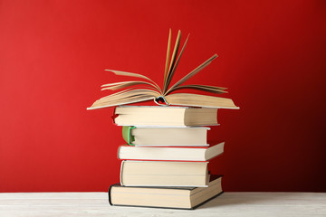 Stack of books against red background, space for text
