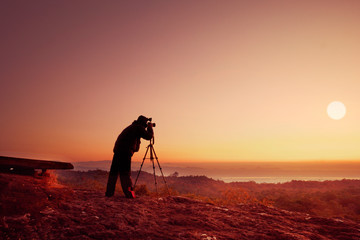 silhouette photographer take photo with sunset or sunrise background