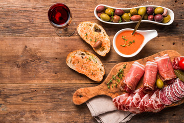 spanish tapas and red wine on wooden table, top view