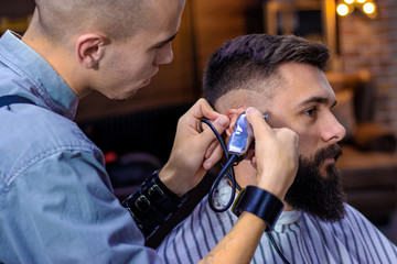 Step 5. Getting perfect shape step by step. Hair styling and cutting with trimmer. Young apprentice...