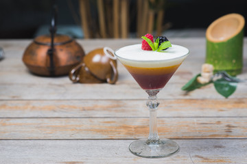 Tiramisu traditional dessert in a glass goblet on a wooden table.