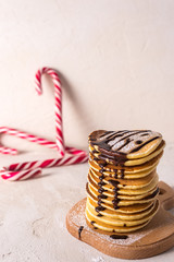  Fresh sweet pancakes with chocolate jam, cinnamon sticks and marshmallows on a gray background with place for your text.