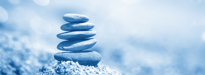Balance of stones on the beach. Color of the year 2020 classic blue toned