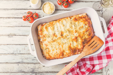 Traditional italian lasagna with vegetables, minced meat and cheese. On a wooden background. Top view, copy space - obrazy, fototapety, plakaty