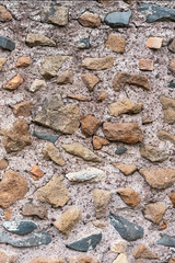 Old stone wall of stones of different sizes and colors as a natural background.