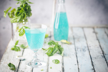 Colorful refreshing summer drink with basil seeds on light background.