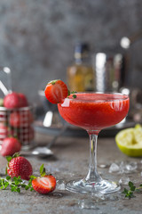 Ice Strawberry alcohol cocktail with lime and rum in a glass