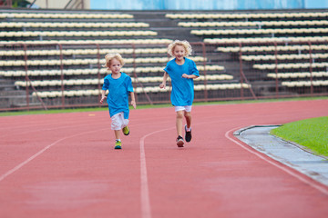 Fototapeta premium Child running in stadium. Kids run. Healthy sport.