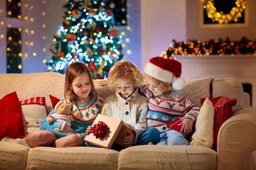 Child at Christmas tree. Kids at fireplace on Xmas