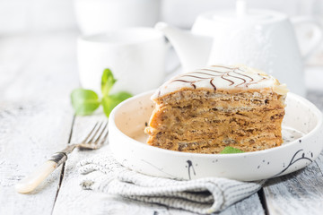 Traditional Hungarian Esterhazy piece of cake on a white wooden background.