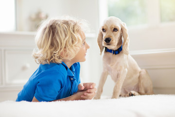 Child playing with dog. Kids play with puppy.