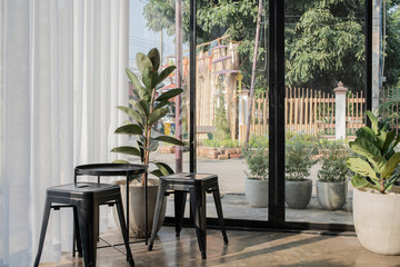Empty on people. Coffee shop interior design With chairs table Steel Black Decorated with clear glass and white curtains with plant pots.