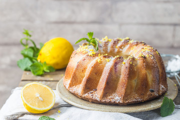 Homemade lemon bundt cake with icing sugar on a black background