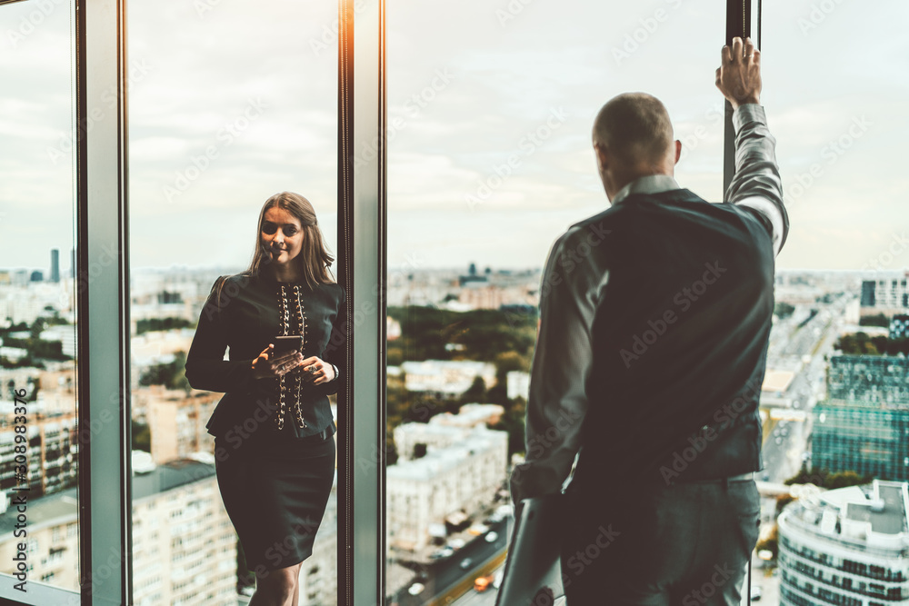 Wall mural a meeting of two entrepreneurs on the top floor of a business skyscraper near the window: a business