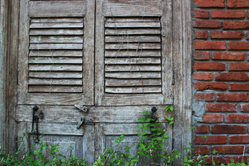 Antique window with a red brick house wall