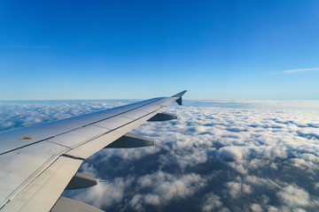 Obraz premium Flugzeug-Flügel über Wolken