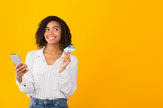 African american girl holding credit card and smartphone