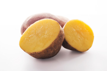 whole and cut potatoes on a white background