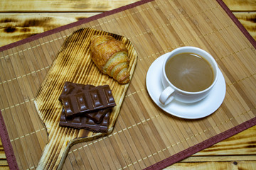 coffee with chocolate and a bun, top view, selective focus