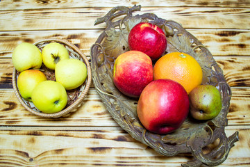 fresh fruits in a straw basket on a wooden background, top view, selective focus