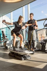 Gordijnen Woman training with personal fitness instructor trainer in modern gym with equipment © rilueda