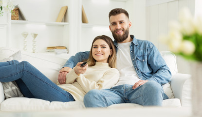 Lazy weekend. Husband and wife watching tv, switching channels