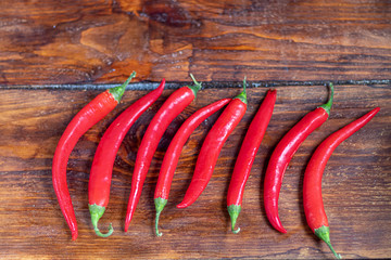 Hot red chili peppers on a wooden surface. Spicy additive in dishes.