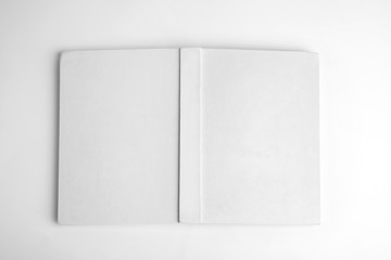 Old book with blank cover on white background, top view