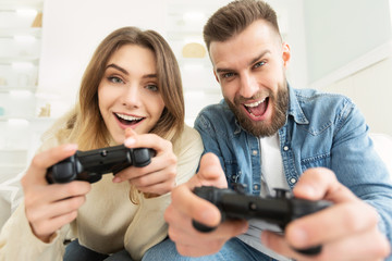 Joyful couple playing video game on Xbox