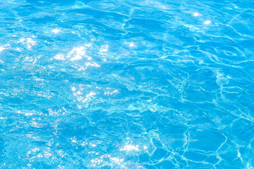 Fototapeta na wymiar surface of blue swimming pool,background of water in swimming pool. texture, blue water, bright rays of the sun