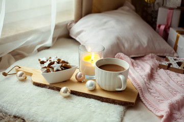 Christmas cookies stars, cocoa on a wooden board. Christmas decor, candles, plaid.