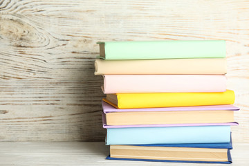 Stack of colorful books on white wooden table