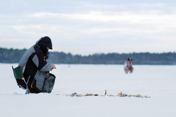 Fototapeta na wymiar winter fishing. male fisherman catches fish in winter. Fishing in the winter, winter sports