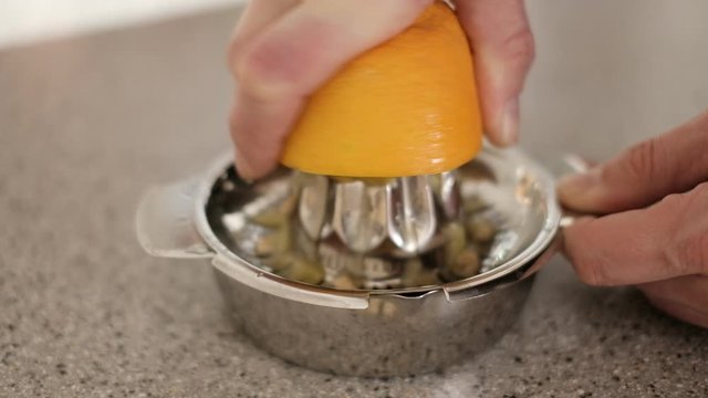 Orange auf einer Zitruspresse auspressen