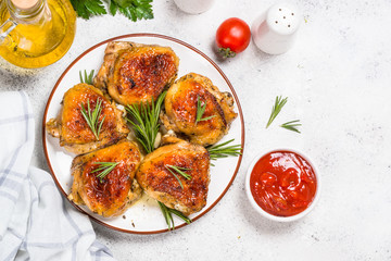 Baked chicken thighs with herbs on white plate.